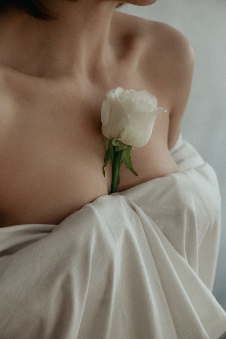 Close-Up Shot of a Woman Holding a White Rose